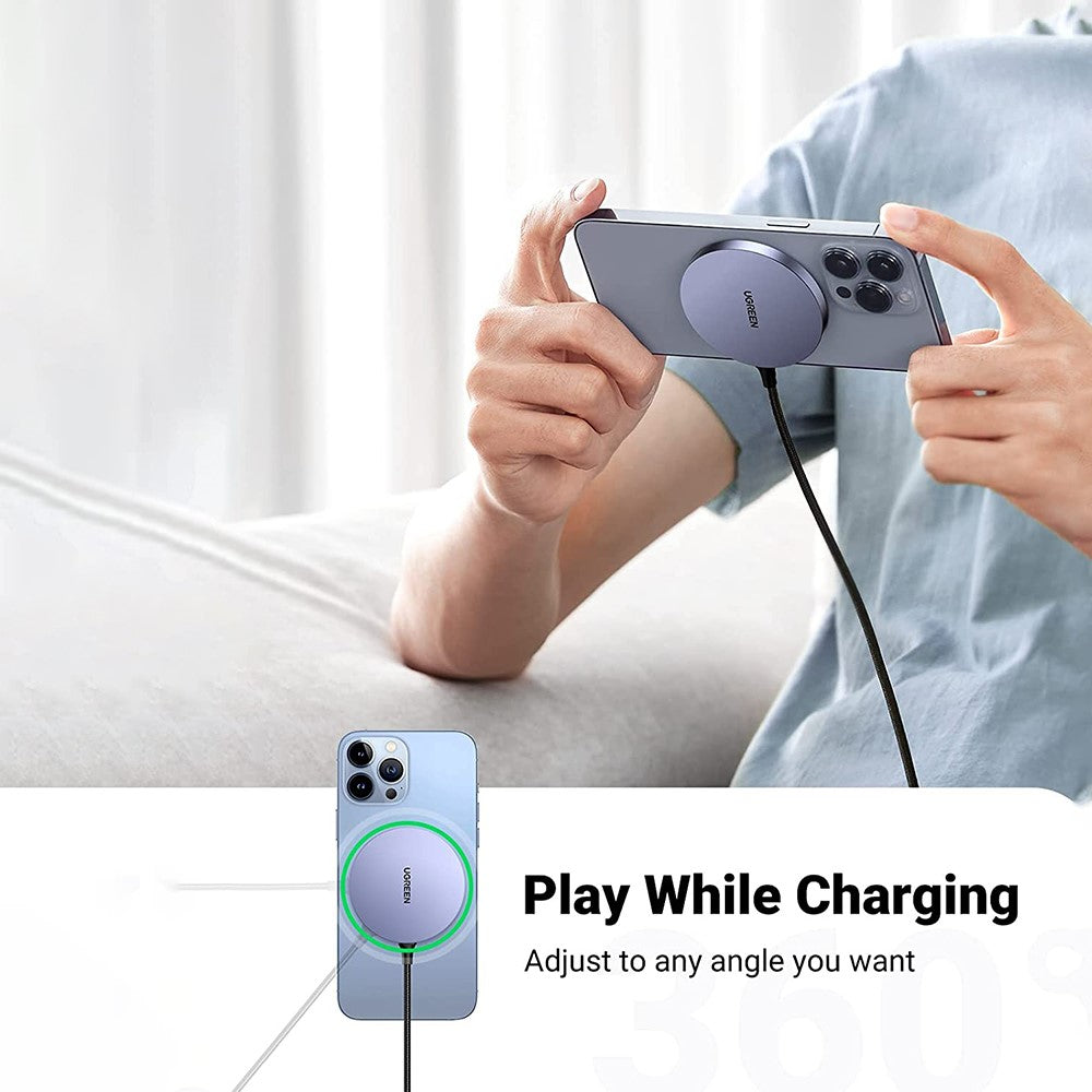 A person holding a phone sideways to play a game while the magnetic charger stays attached to the back