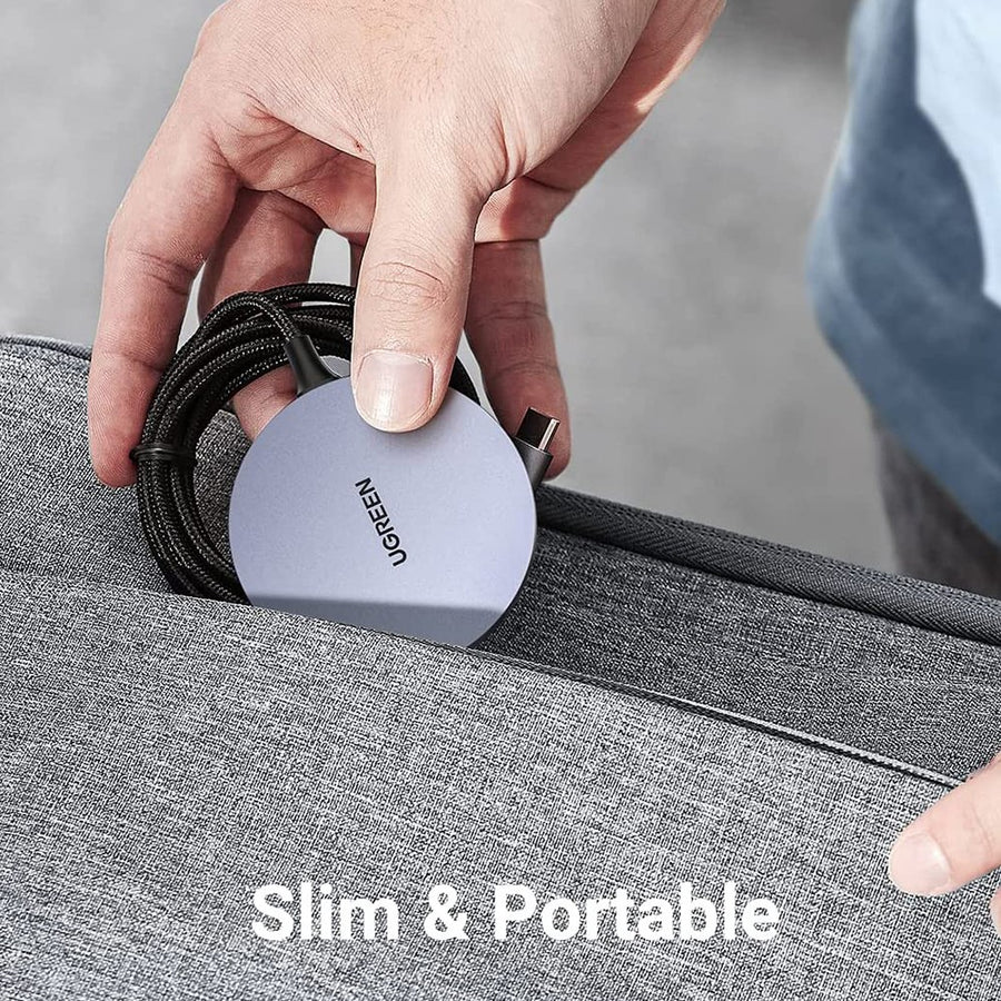A hand tucking the slim charger and its coiled cable into a grey laptop sleeve, captioned slim and portable