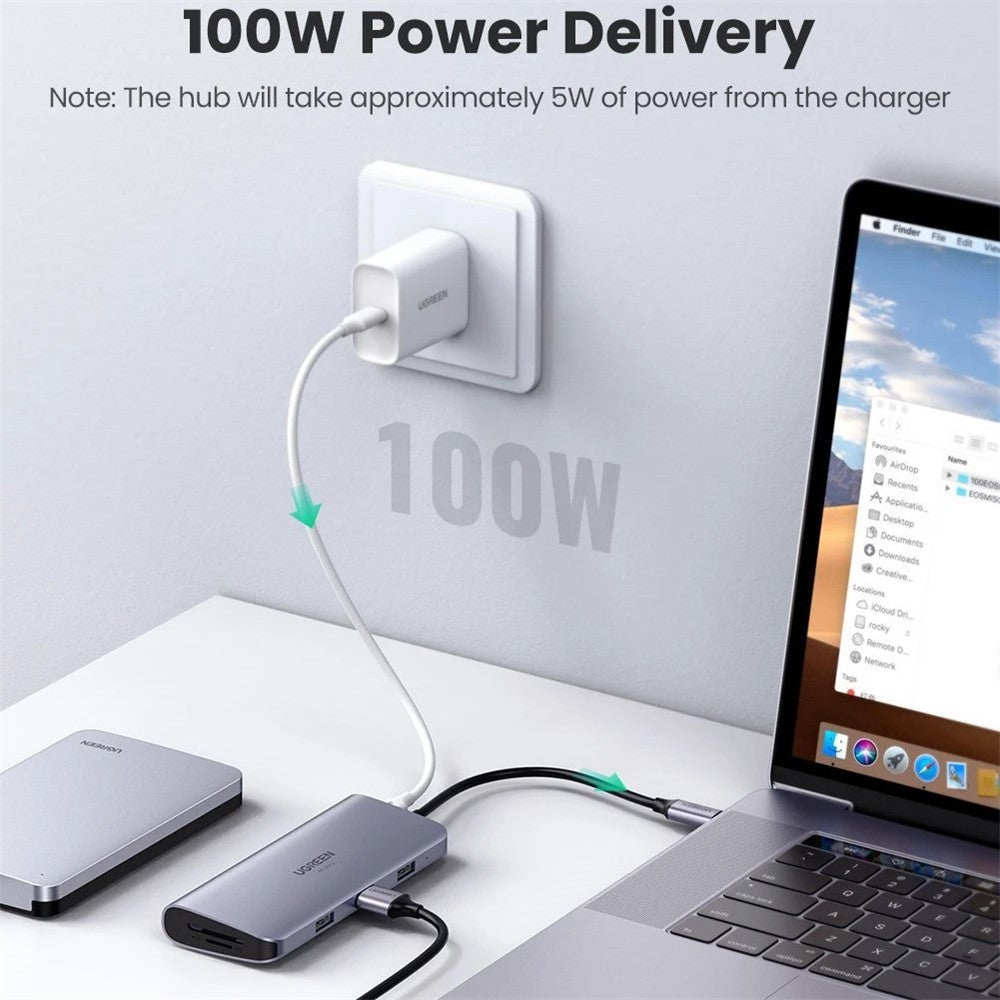 The dock charging a laptop from a wall socket, captioned 100W power delivery with a note that the hub uses about 5W