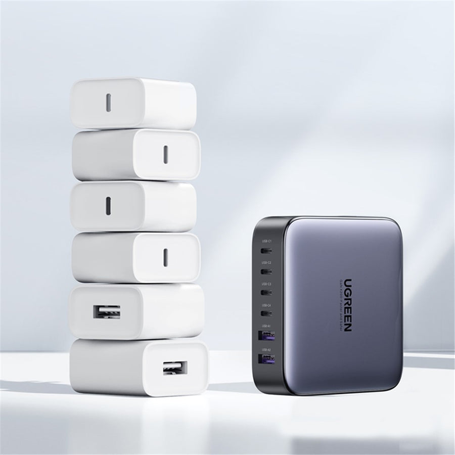 The single UGREEN charger beside a stack of six white wall adapters it replaces