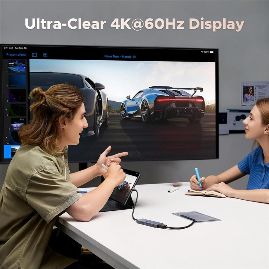 Two colleagues in a meeting room watching a 4K 60Hz presentation run through the hub
