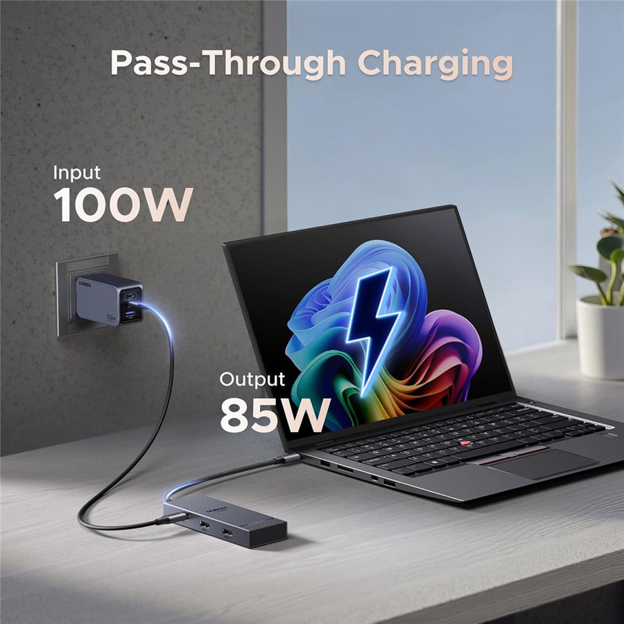 The dock charging a laptop from a wall socket, labelled 100W input and 85W output