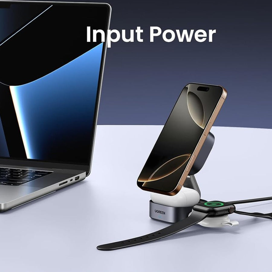 The charger opened on a desk next to a laptop, holding an iPhone upright with its cable running off-frame